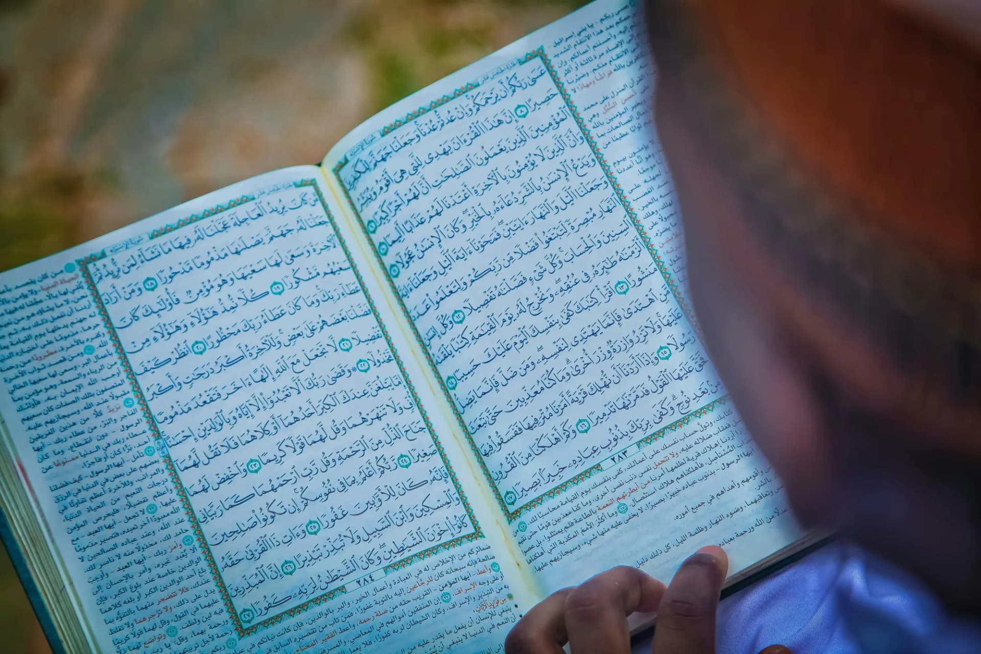 A Quran open beside a window with morning light falling across the page
